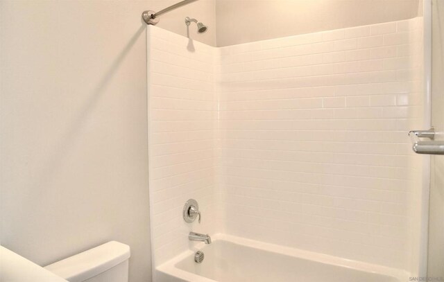 bathroom featuring bathtub / shower combination and toilet