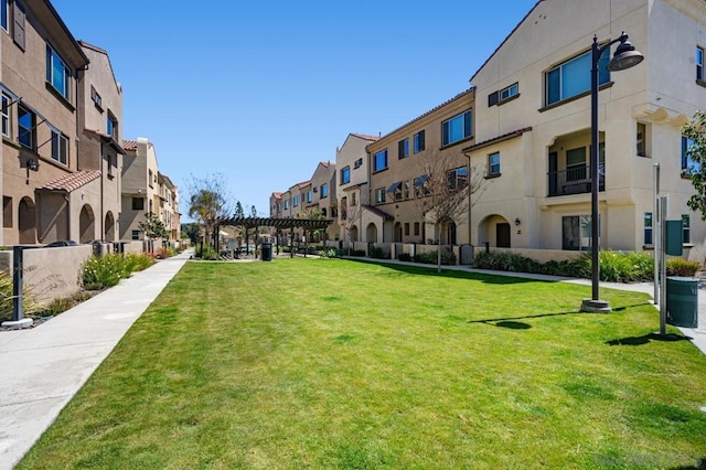 view of community with a pergola and a yard