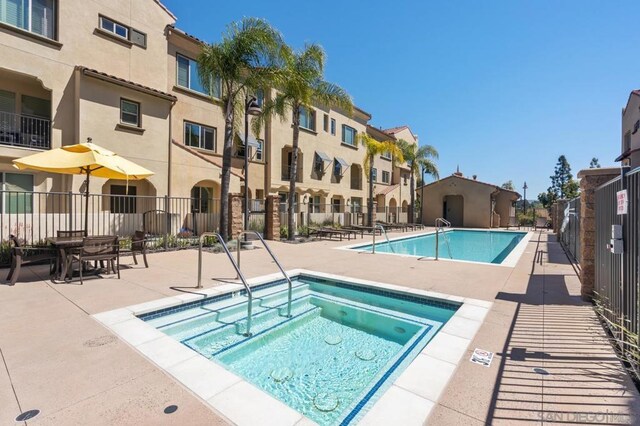 view of swimming pool featuring a patio area and a hot tub