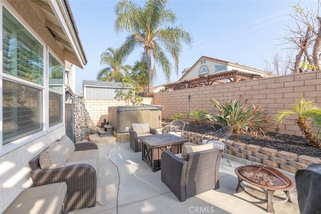 view of patio / terrace featuring an outdoor living space with a fire pit and a hot tub