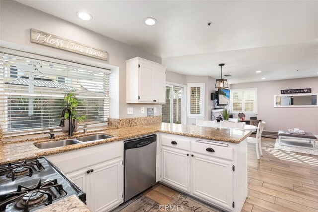 kitchen with white cabinetry, sink, kitchen peninsula, stainless steel dishwasher, and stove