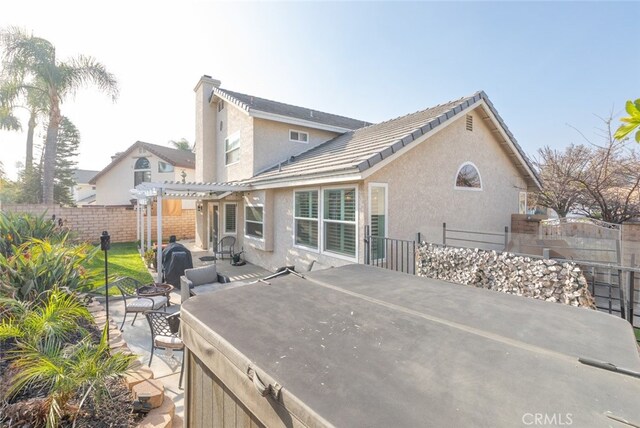 rear view of house with a pergola and a patio