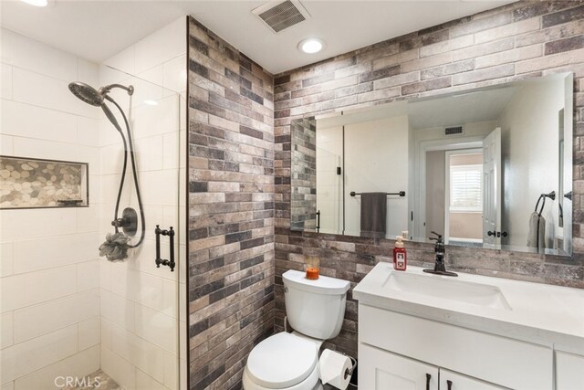 bathroom with toilet, a shower with shower door, and vanity