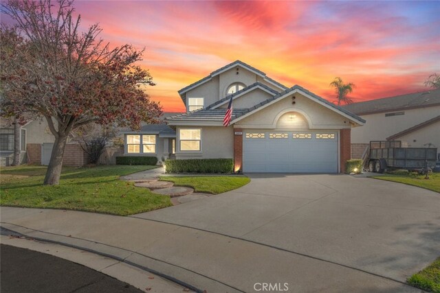 front of property with a garage and a yard