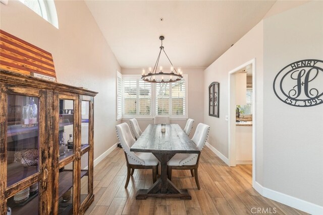 dining room with an inviting chandelier and light hardwood / wood-style flooring