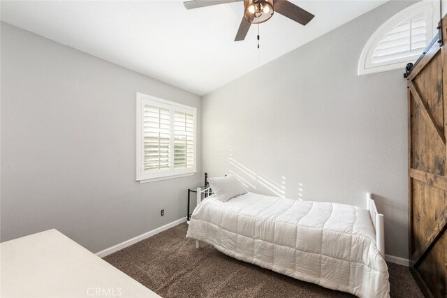 bedroom featuring ceiling fan, a barn door, vaulted ceiling, and carpet