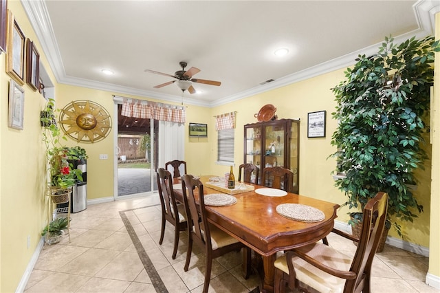 dining space with ceiling fan, light tile patterned flooring, and ornamental molding