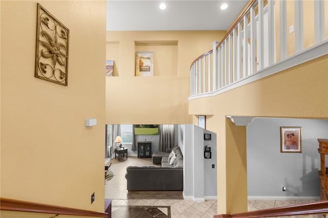 stairway featuring a high ceiling and tile patterned floors