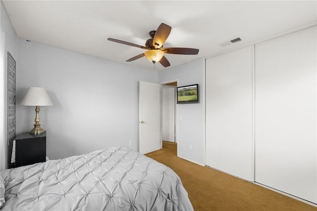 bedroom featuring ceiling fan, a closet, and light carpet