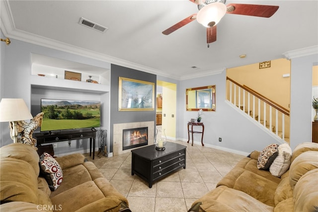 tiled living room featuring built in shelves, a tile fireplace, and ornamental molding