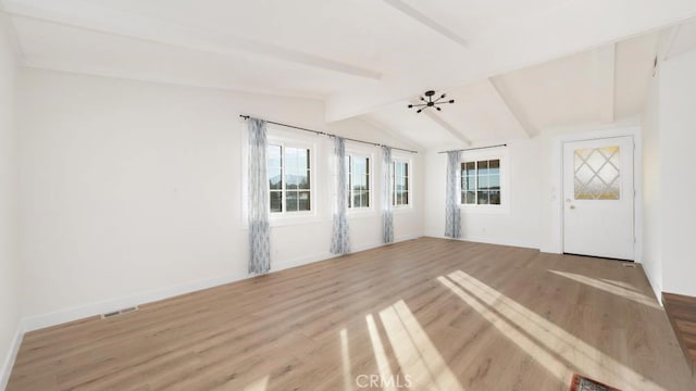 empty room featuring lofted ceiling with beams and hardwood / wood-style flooring