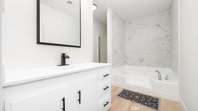 bathroom featuring vanity, independent shower and bath, and hardwood / wood-style flooring