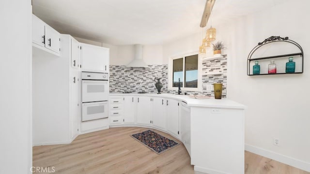 kitchen with white cabinetry, extractor fan, decorative backsplash, pendant lighting, and double oven