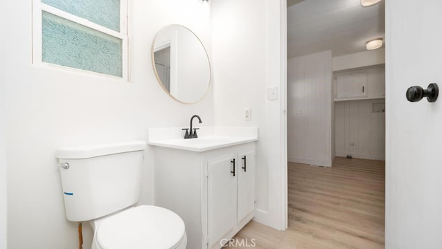 bathroom with wood-type flooring, toilet, and vanity