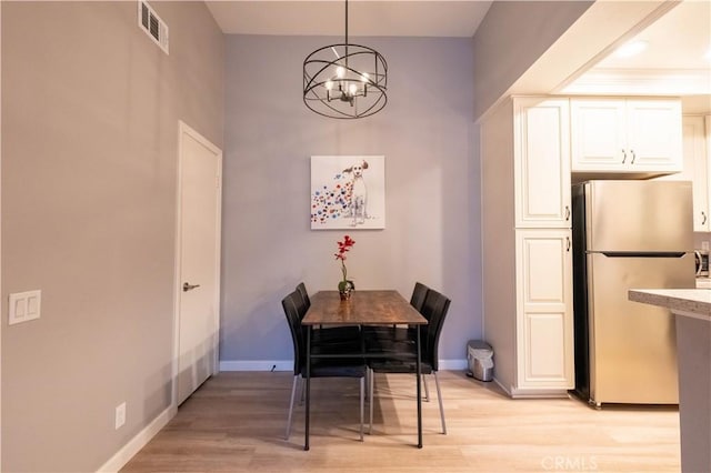 dining space with a chandelier and light hardwood / wood-style floors