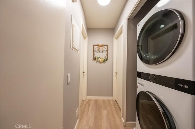 washroom featuring light hardwood / wood-style floors and stacked washer / drying machine