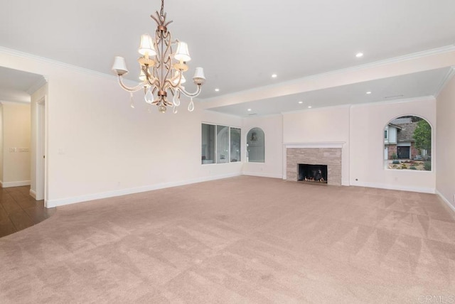 unfurnished living room featuring light carpet, an inviting chandelier, a tile fireplace, and crown molding