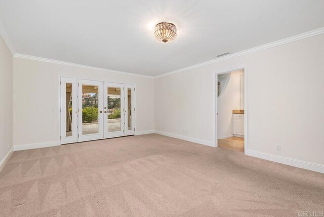 carpeted empty room with ornamental molding and french doors