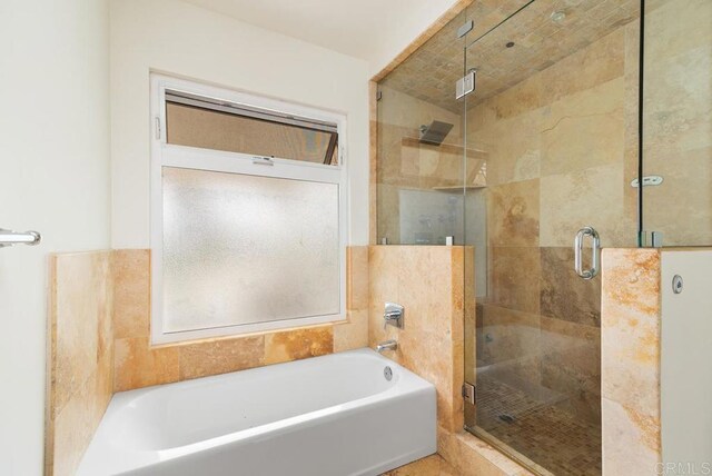 bathroom featuring independent shower and bath