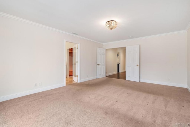 empty room with crown molding and carpet flooring