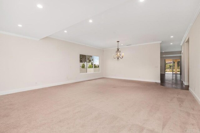 unfurnished room featuring light colored carpet, an inviting chandelier, and ornamental molding