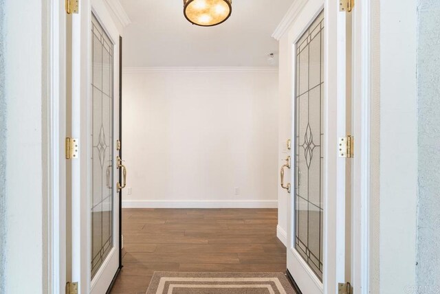 foyer entrance featuring dark wood-type flooring and crown molding