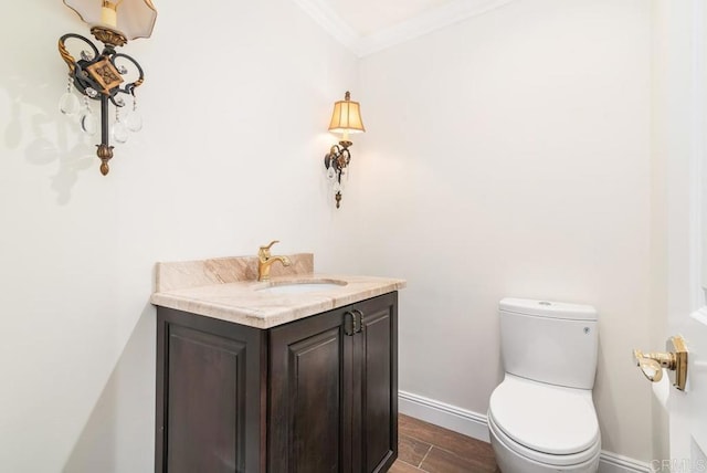 bathroom with toilet, vanity, and ornamental molding