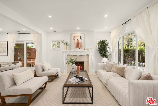 carpeted living room with a high end fireplace