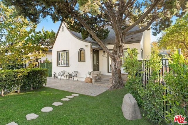 back of house featuring a lawn and a patio