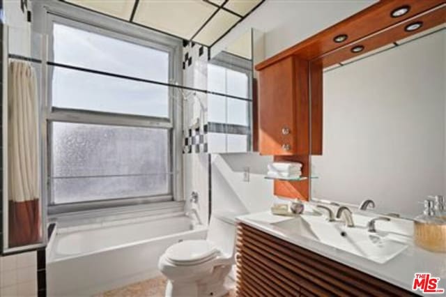 full bathroom featuring toilet, vanity, and shower / bath combo with shower curtain