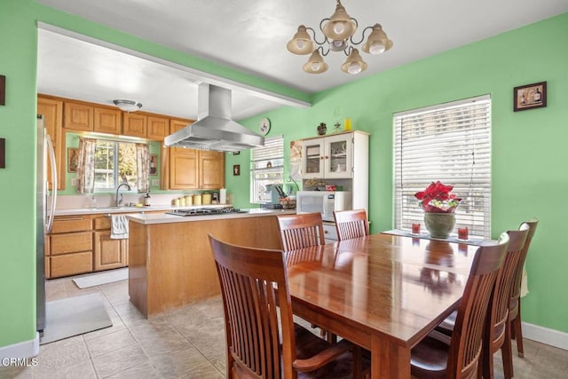 tiled dining space with plenty of natural light, sink, and an inviting chandelier