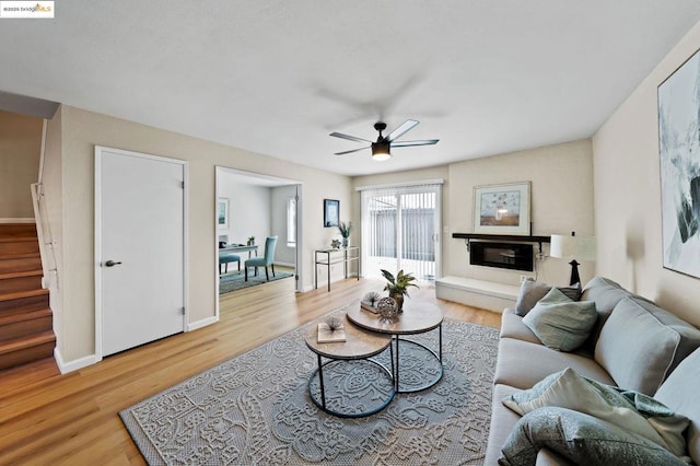 living room featuring ceiling fan and light hardwood / wood-style flooring