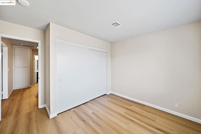 unfurnished bedroom with light hardwood / wood-style floors and a closet