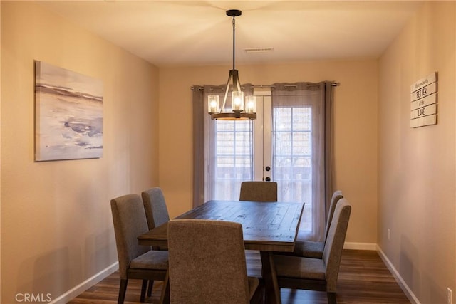 dining space with a chandelier and dark hardwood / wood-style floors