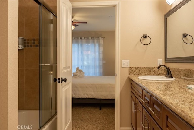 bathroom with ceiling fan, vanity, and bath / shower combo with glass door