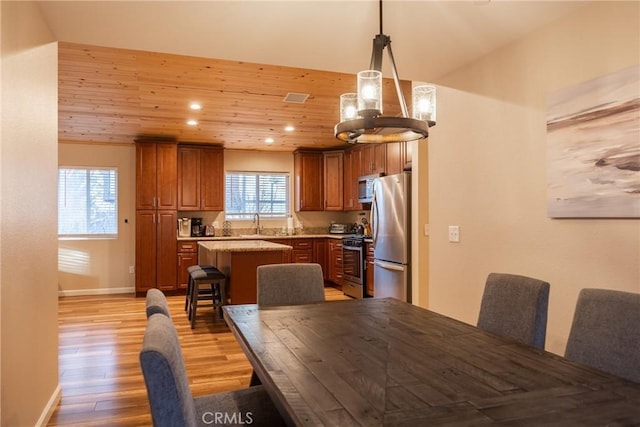 dining space with wood ceiling, sink, and light hardwood / wood-style flooring