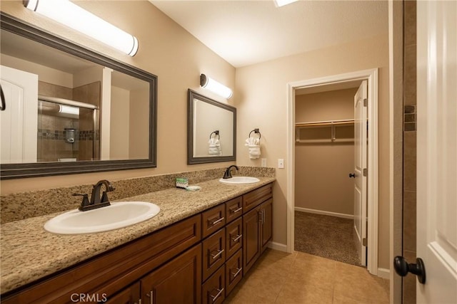 bathroom with an enclosed shower, vanity, and tile patterned flooring