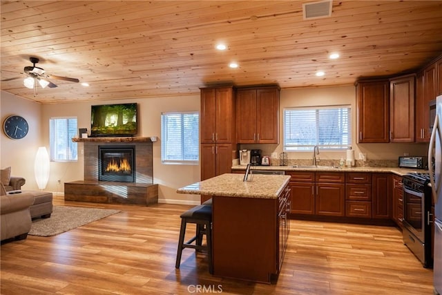 kitchen featuring light hardwood / wood-style floors, wooden ceiling, sink, and a kitchen island