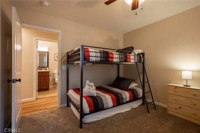 bedroom with ceiling fan, connected bathroom, and light carpet