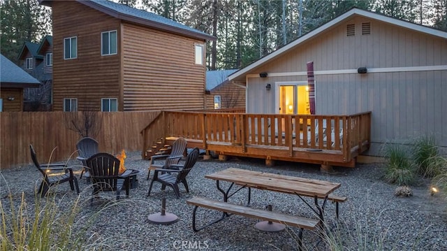 rear view of property featuring a deck and an outdoor fire pit