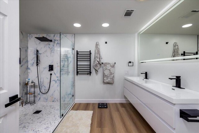 bathroom featuring a tile shower, hardwood / wood-style floors, and vanity