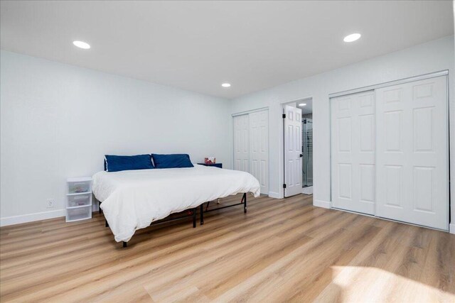 bedroom featuring two closets and light wood-type flooring