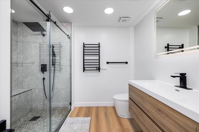 bathroom featuring toilet, hardwood / wood-style floors, an enclosed shower, radiator, and vanity