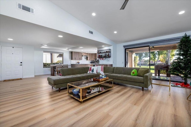 living room with vaulted ceiling and light hardwood / wood-style flooring