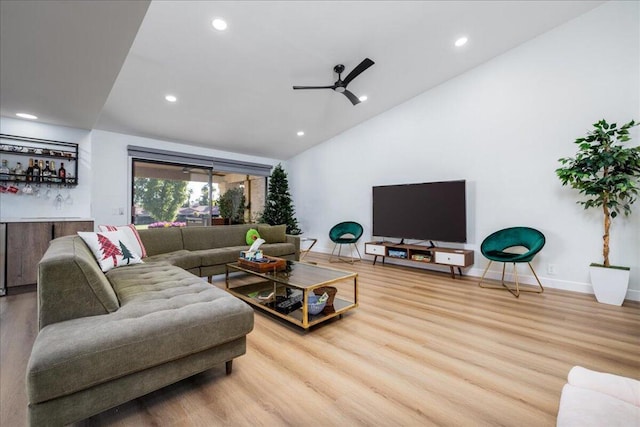 living room featuring vaulted ceiling, ceiling fan, and hardwood / wood-style flooring