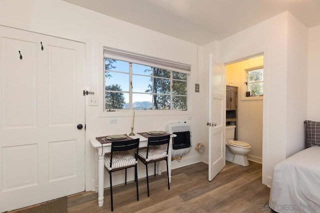 bathroom with wood-type flooring, toilet, and heating unit