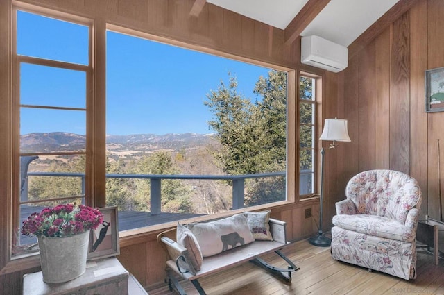 sunroom / solarium featuring beamed ceiling, a mountain view, and a wall mounted air conditioner