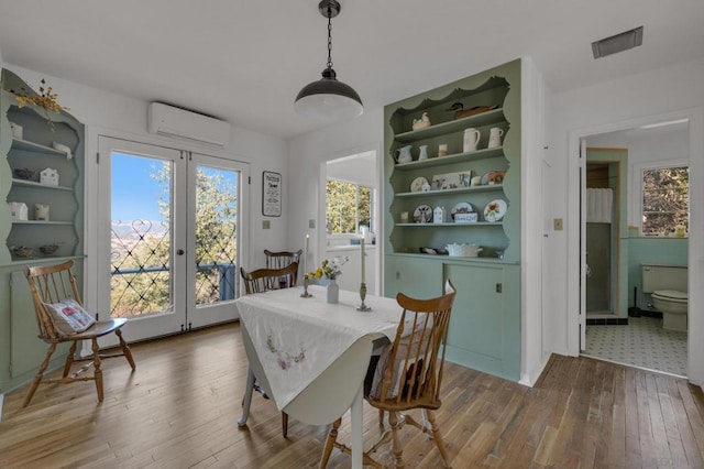 dining space with hardwood / wood-style flooring and a wall mounted air conditioner