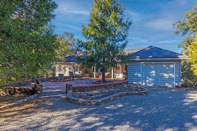 view of front facade with a garage and a patio