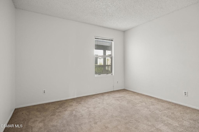 carpeted spare room featuring a textured ceiling